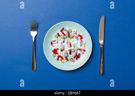 Many different weight loss pills and supplements as food on round plate. Pills served as a healthy meal. Drugs, pharmacy, medicine or medical healthyc Stock Photo