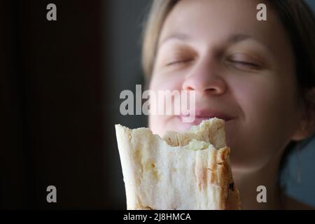 Young woman eating tasty shawarma, yummy snack