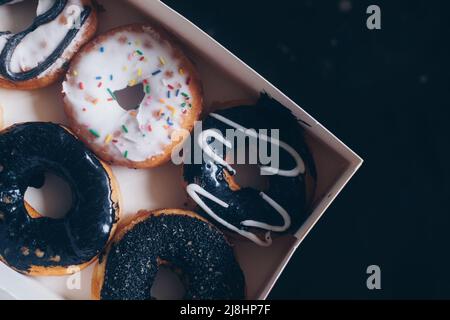 Closeup of flat lay of five fresh ring donuts in white box. Selective focus. Stock Photo