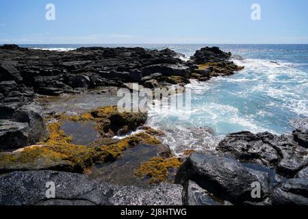 Waves crashing on the lava rocks of South Point Park, the southernmost point of the United States on the Big Island of Hawaii in the Pacific Ocean Stock Photo