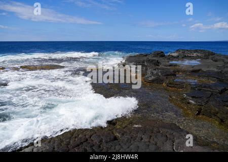 Waves crashing on the lava rocks of South Point Park, the southernmost point of the United States on the Big Island of Hawaii in the Pacific Ocean Stock Photo