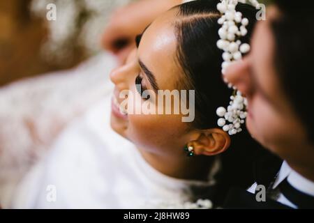 Latina bride and multiracial groom snuggle after the wedding ceremony Stock Photo
