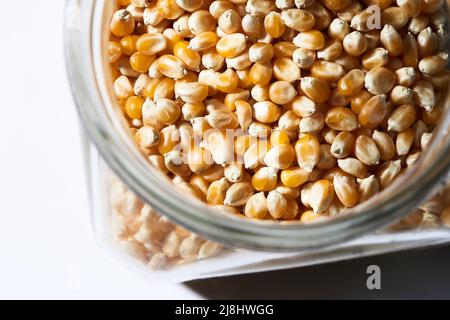 popcorn kernels in jar on white Stock Photo