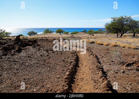 Rocky trail path leading to the ancient fishing village in ruins in the Lapakahi State Historical Park on the island of Hawai'i (Big Island) in the Pa Stock Photo