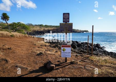 Warning sign on Old Coast Guard Beach in the north of Big Island, Hawaii - Rocky shore in the Kohala Historical Sites State Monument Stock Photo