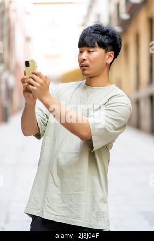 Asian sending a message from his new smartphone Stock Photo