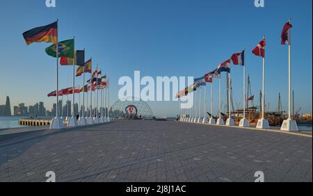 The FIFA World Cup Qatar 2022 Official Countdown Clock  at Doha’s picturesque Corniche Fishing Spot with flags of participating countries Stock Photo