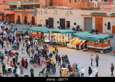 MARRAKECH, MOROCCO - FEBRUARY 20, 2022: People visit Jamaa el-Fnaa square market of Marrakech city, Morocco. The square is listed as UNESCO Masterpiec Stock Photo