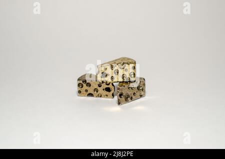 Three Wedges of Swiss Cheese - Miniature Gold Metal Pewter Collectible Figurine, in Center on Plain Background Stock Photo