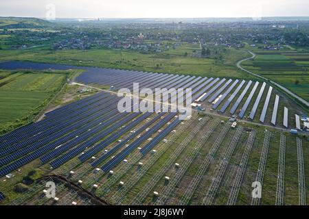 Aerial view of big electric power plant under construction with many rows of solar panels on metal frame for producing clean electrical energy Stock Photo