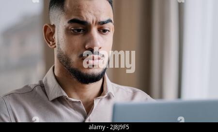 Exhausted young millennial businessman overworked male worker employee massaging dry irritable eyes feeling eyestrain after using computer tired Stock Photo