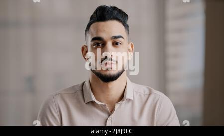 Close up serious portrait hispanic young business man entrepreneur professional worker thoughtful male face show facial expression confident eyesight Stock Photo