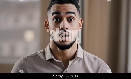 Close up shocked happy young hispanic male business man professional worker surprised looking at camera make big eyes rejoice victory amazed guy Stock Photo