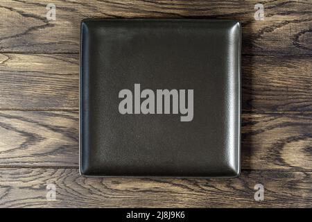 Empty rectangular black plate on oak wooden background. Top view, with copy space Stock Photo
