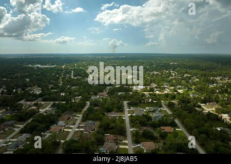 Landscape of dark ominous clouds forming on stormy sky before heavy thunderstorm over rural town area Stock Photo