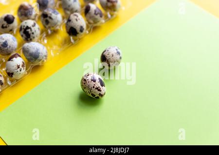 Three quail Easter eggs lying on two beige pastel shades with a hard shadow. Trendy isometric beige background. Stock Photo