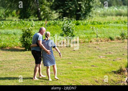 romantic middle-aged couple are walking in the garden, happy relationship concept Stock Photo
