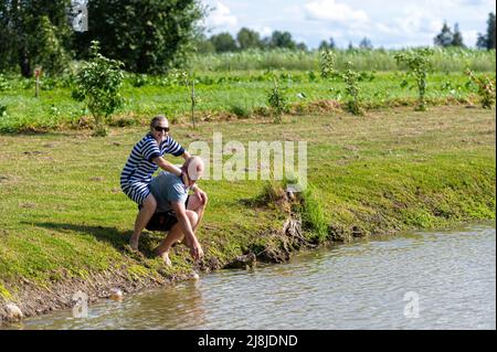 romantic middle-aged couple having fun at the pond, the concept of a happy relationship Stock Photo