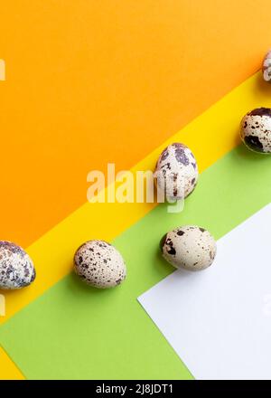 Three quail Easter eggs lying on two beige pastel shades with a hard shadow. Trendy isometric beige background. Stock Photo