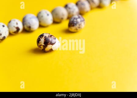 Three quail Easter eggs lying on two beige pastel shades with a hard shadow. Trendy isometric beige background. Stock Photo