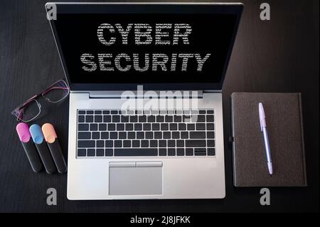 Top view of laptop with text cyber security. Cyber security inscription on laptop screen and keyboard. Stock Photo