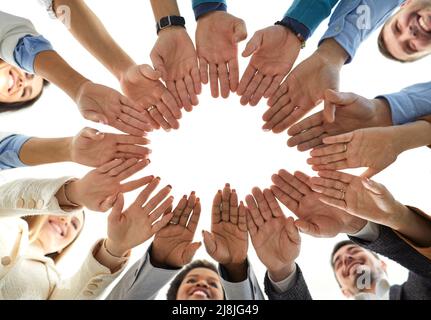 Low angle shot of multi-ethnic business group of men and women with stacked hands Stock Photo