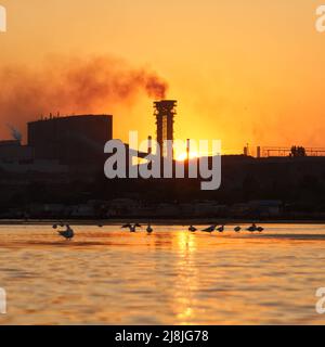 Dramatic Sea sunset over the industrial zone of Azovstal plant in Mariupol city before the start of the 2022 war in Ukraine Stock Photo