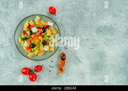 Pasta with vegetables, sauce, mozzarella cheese on a light textured background. Italian pasta with vegetables and spices on a dark background. Stock Photo