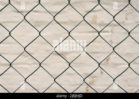 metal mesh and a brick wall behind it Stock Photo