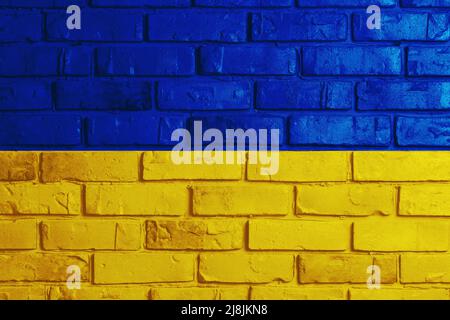 Ukrainian flag on a textured background. The flag of Ukraine on the old grunge wall in the background, the concept of destruction and war in Ukraine.S Stock Photo