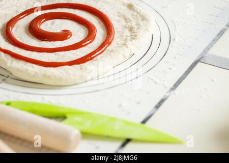 Berry jam spirally applied to rolled out dough for a sweet dessert roll Stock Photo