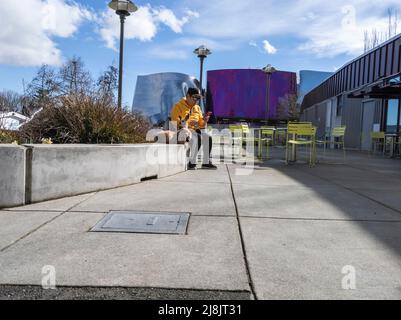 Seattle, WA USA - circa April 2022: View of a man hanging out with his two dogs outside near the Seattle Center area Stock Photo