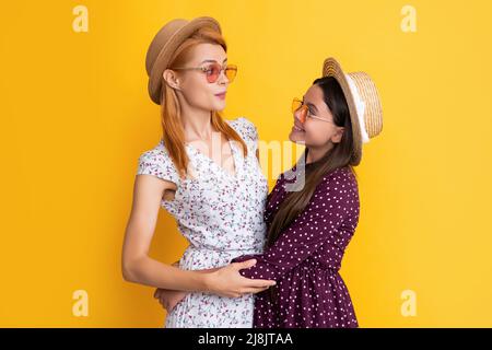 cheerful mother and child in straw hat on yellow background Stock Photo