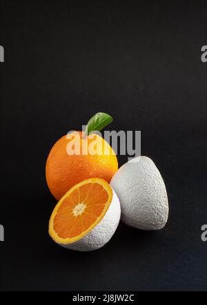 Fresh organic and white colored orange fruit on black background. Minimal food  concept. Stock Photo