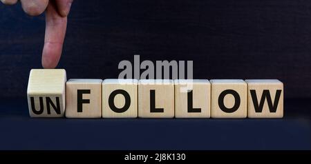 Follow or unfollow symbol. Turned wooden cubes and changed concept words Follow to Unfollow. Beautiful grey table grey background. Business and follow Stock Photo