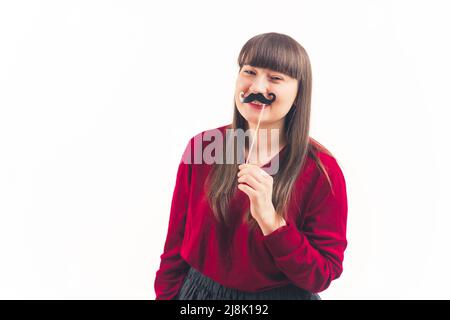 Pretty young woman holds fake moustache on a stick movember white background copy space isolated studio shot medium shot . High quality photo Stock Photo