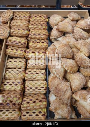 Freshly baked sweet frozen puff shortcrust pastry with jam, vanilla pudding and cream cheese in bakery. Fresh pocket pastries dessert or afternoon snack from grocery store Stock Photo