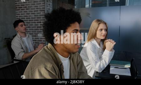 Young diverse group students sitting in classroom at lesson answering question discussing new topic with teacher communicate with lecturer studying at Stock Photo