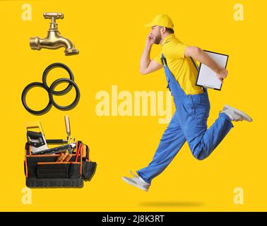 Running male plumber and different equipment on yellow background Stock Photo