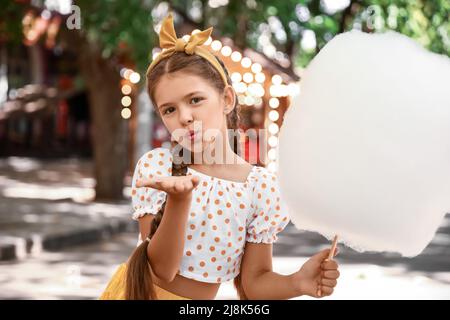 Cute little girl with cotton candy outdoors Stock Photo