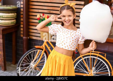 Cute little girl with cotton candy outdoors Stock Photo