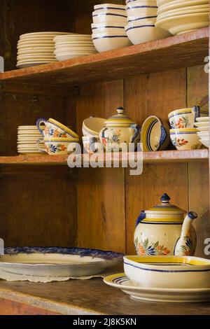 Antique crockery buffet with fine dishes in kitchen inside old circa 1780 French regime cottage style home. Stock Photo