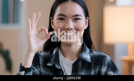 Female portrait happy recommending smiling winner asian woman girl showing ok gesture everything fine sign success good news done consent victory Stock Photo