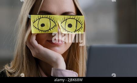 Close-up sleeping girl funny lazy caucasian business woman tired sleepy female worker with sticky notes on eyes glasses with stickers sleeps in office Stock Photo