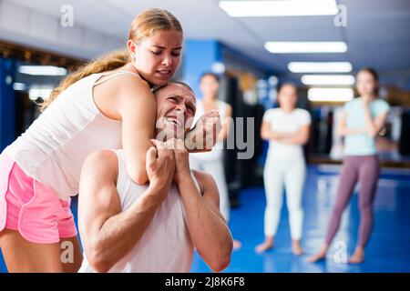 Woman makes a choke hold in self-defense training Stock Photo - Alamy