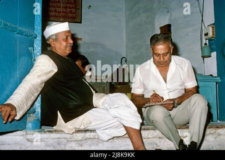 Man leaning against blue wall during business meeting in New Delhi, India 1986 Stock Photo