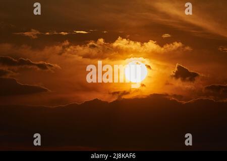 Sunset through cloudy red sky Stock Photo