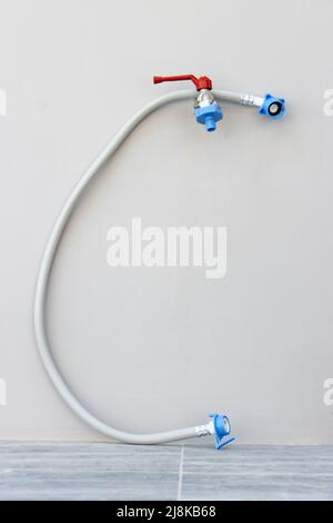 Outdoor water tap with washing machine hose ready for connection Stock Photo