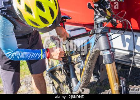 Unrecognizable man holding or holding his bike from a pick up Stock Photo