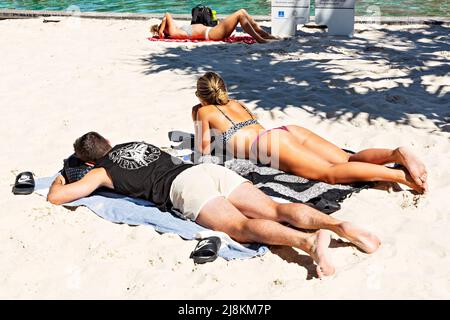 Brisbane Australia / A young couple enjoy the sunshine at Streets Beach an urban man made swimming beach. Stock Photo